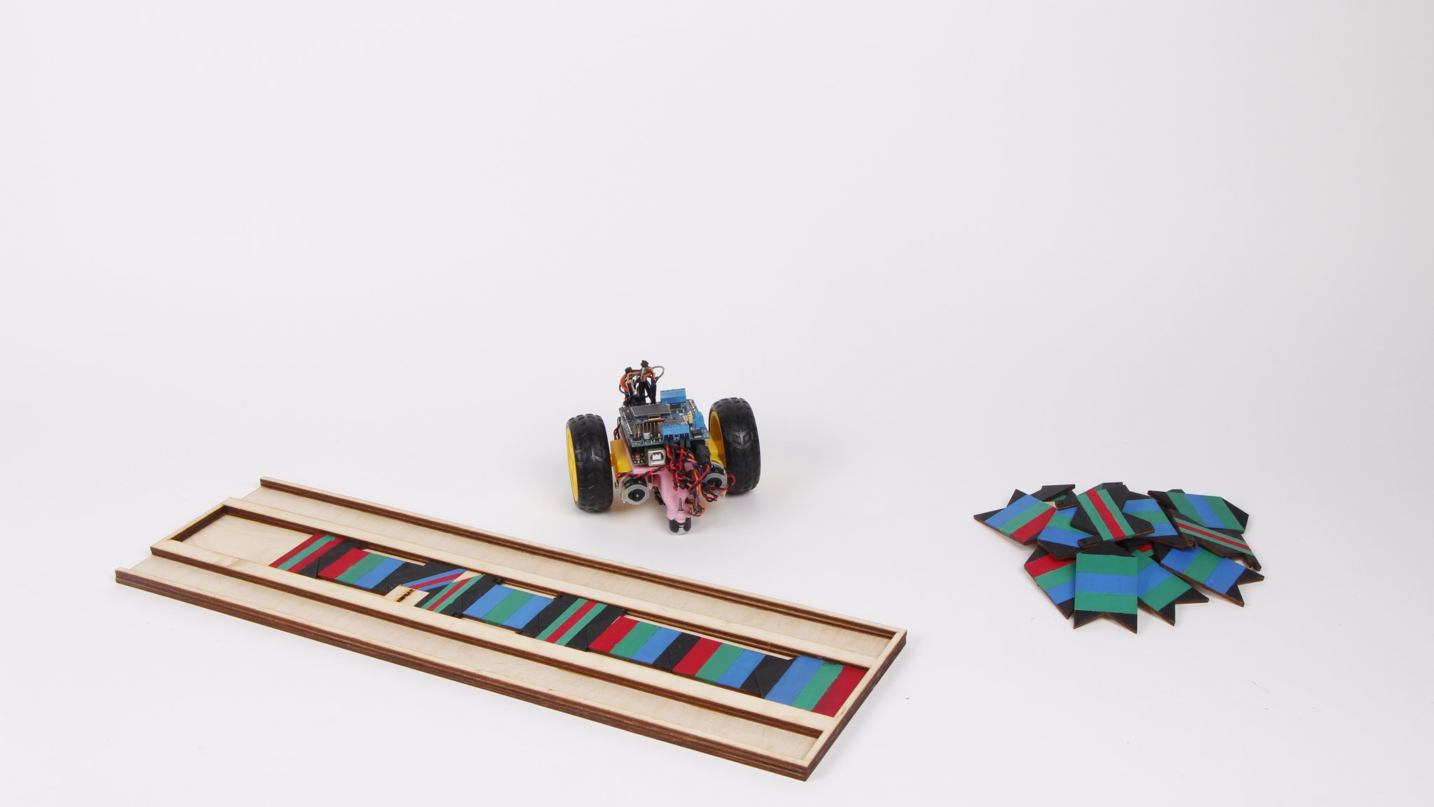 Code Cruiser robot with colorful programming tiles arranged on a white surface