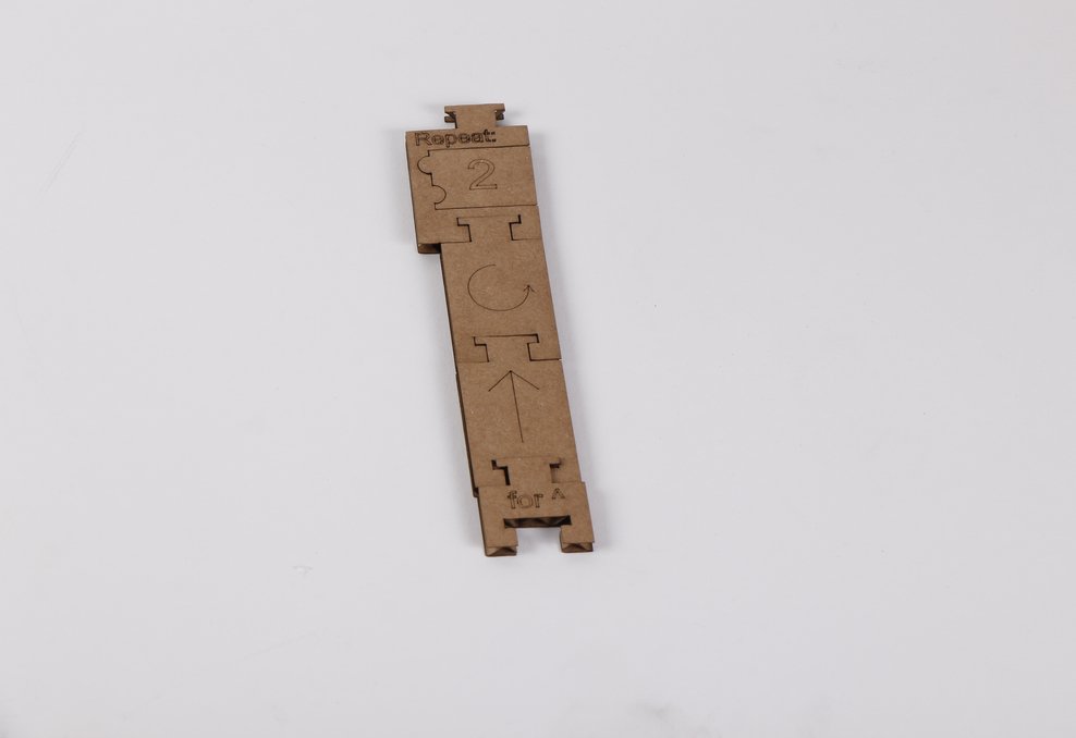 Laser-cut wooden tile holder with organized programming blocks